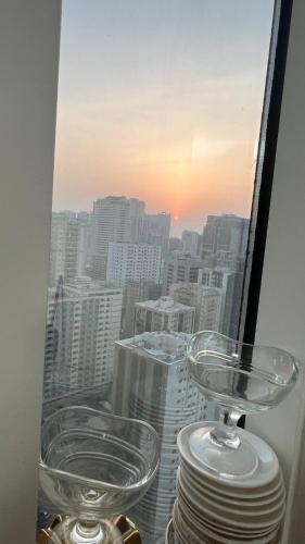 a view of a city skyline from a window with glasses at AlNahda Border SHJ-DXB- 2BADROOM AND HALL FULL FLAT FOR YOU ONLY in Sharjah