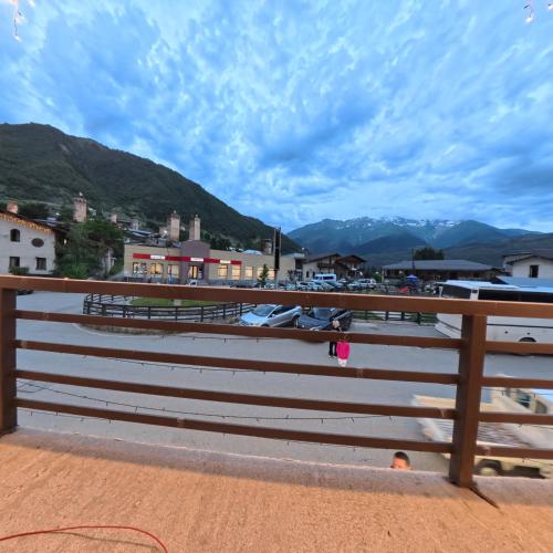 a fence with a view of a town and mountains at Shara Hotel in Mestia