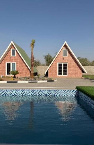 una casa con piscina di fronte a una casa di Malina Resort a Ras al Khaimah