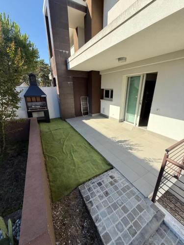 a backyard of a house with a lawn at Villa Pinewood in Lignano Sabbiadoro