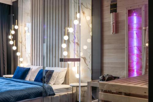 a bedroom with a bed with lights on the wall at SAUNA JACUZZI River View QUORUM Apartment in Wrocław