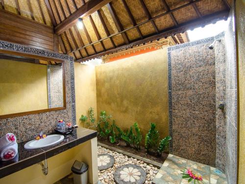 Un baño con ducha con lavabo y espejo. en Cassava Bungalow, en Nusa Lembongan