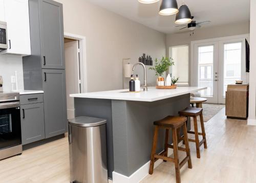 a kitchen with a large island in a kitchen with stools at The Magnolia Stay in Fort Worth