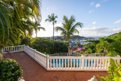 a white fence on a balcony with palm trees at Viewstar in Gustavia