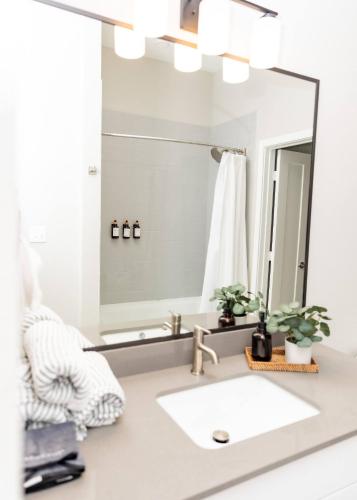 a bathroom with a large mirror and a white sink at The Magnolia Stay in Fort Worth