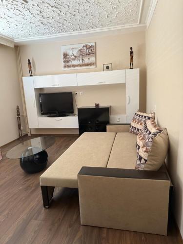 a living room with a couch and a flat screen tv at Central apartments Pleven in Pleven