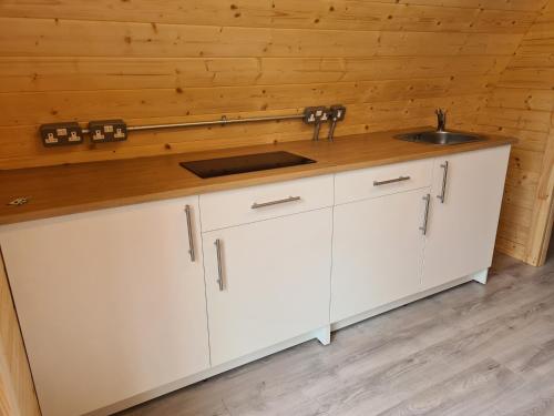 a kitchen with white cabinets and a sink at Gouladoo Retreat in Bantry