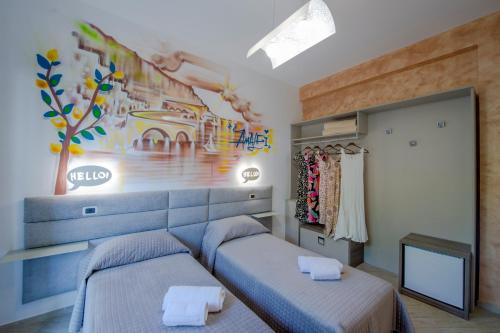 a bedroom with two beds and a painting on the wall at B&B Casanova in Agerola