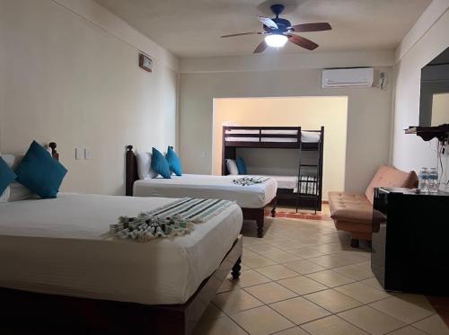 a bedroom with two beds and a bunk bed at HOTEL EL CORAL in Punta Mita