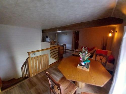a living room with a wooden table and a kitchen at Chambre prairie in La Roche-sur-Yon