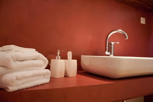 a bathroom with a sink and towels on a counter at La Ferme Aux Arts in Beaumont-sur-Grosne