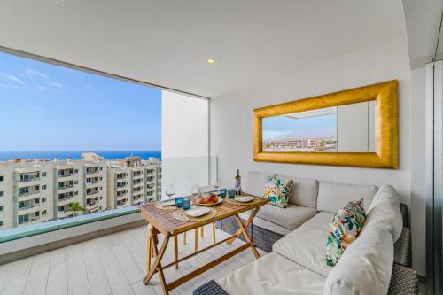 a living room with a couch and a table at Blue Gold Escape - Ocean view, airco, heated pool in Adeje
