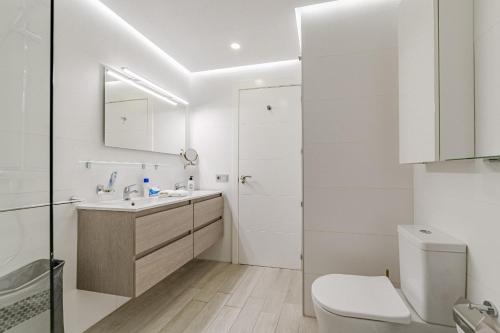 Un baño blanco con lavabo e inodoro. en Blue Gold Escape in Ocean Garden, en Adeje