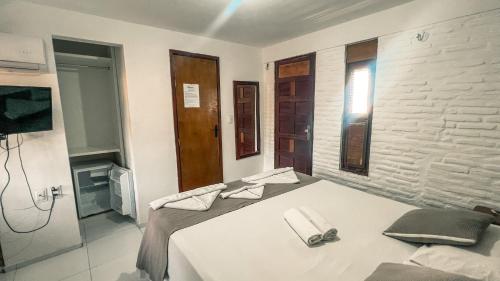 a bedroom with a bed with towels on it at Falésia Praia Hotel in Canoa Quebrada
