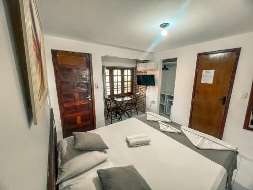 a room with a bed and a table and chairs at Falésia Praia Hotel in Canoa Quebrada