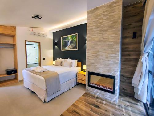 a bedroom with a bed and a fireplace at Hotel Boutique Vinícola Araucária by Slaviero Hotéis in São José dos Pinhais