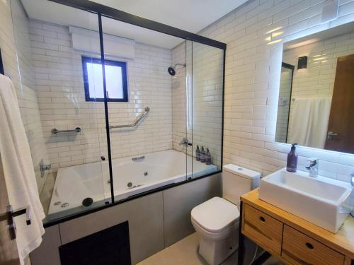a bathroom with a tub and a toilet and a sink at Hotel Boutique Vinícola Araucária by Slaviero Hotéis in São José dos Pinhais