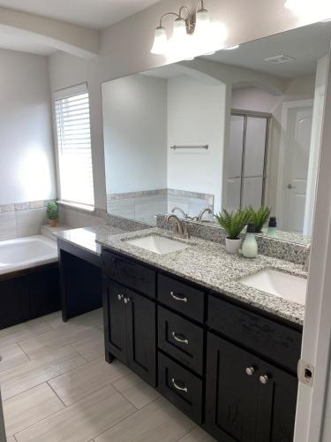 a bathroom with two sinks and a large mirror at Central NWA-Games, Concerts, Nature and More in Lowell