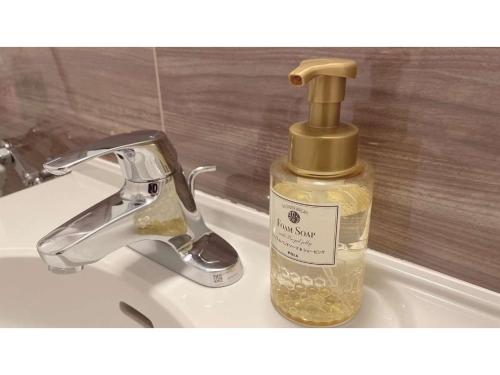 a bottle of soap sitting next to a bathroom sink at Smile Hotel Premium Sapporo Susukino - Vacation STAY 64521v in Sapporo
