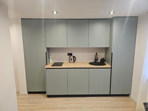 una cucina con mobili bianchi e un lavandino di Zvaigžņu apartment a Riga