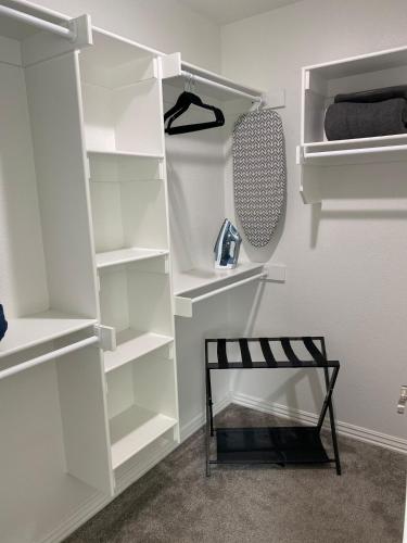 a closet with white shelves and a black chair at Central NWA-Games, Concerts, Nature and More in Lowell