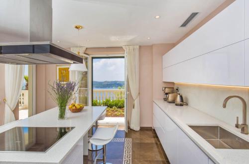 eine Küche mit weißen Arbeitsplatten und Meerblick in der Unterkunft Beautiful Dubrovnik Villa 5 Bedrooms Villa Gold Dubrovnik Stylish Furnishings Wonderful Sea Views Orasac in Orasac