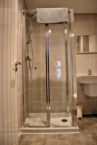 a shower with a glass door in a bathroom at Lower Townhouse, Exeter in Alphington