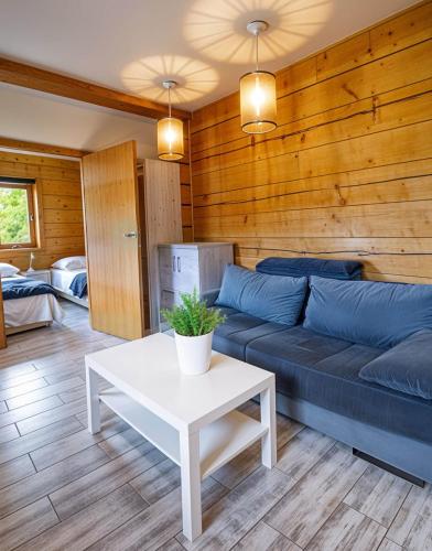 a living room with a blue couch and a table at W Dolinie Bobru in Trzcińsko
