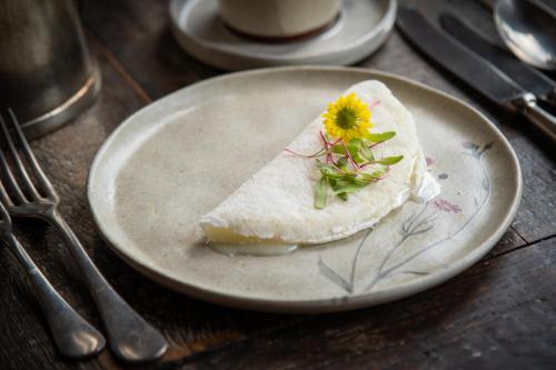 a plate with a piece of food with a flower on it at Santa Teresa Hotel Rio de Janeiro - MGallery Collection in Rio de Janeiro
