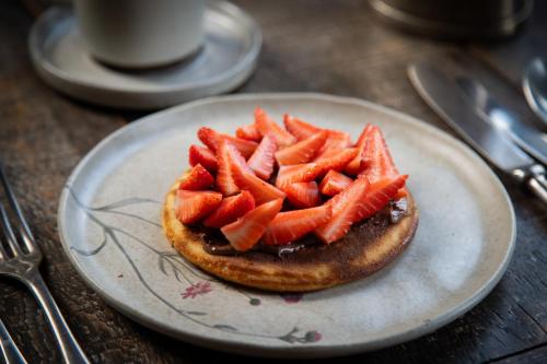 a sandwich with strawberries on a plate on a table at Santa Teresa Hotel Rio de Janeiro - MGallery Collection in Rio de Janeiro