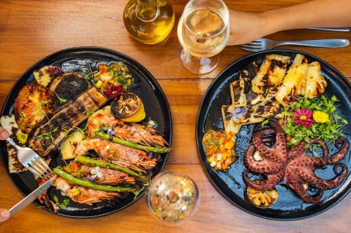 two plates of food with an octopus on a table at Santa Teresa Hotel Rio de Janeiro - MGallery Collection in Rio de Janeiro