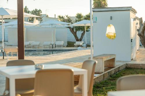 a restaurant with tables and chairs and umbrellas at Boomerang Village in Torre Colimena