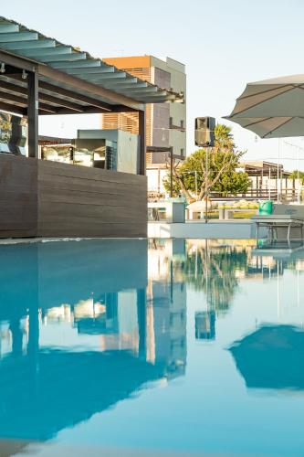 a pool of water in front of a building at Boomerang Village in Torre Colimena