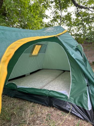 a green tent on the grass in a field at Camping Garni in Garni
