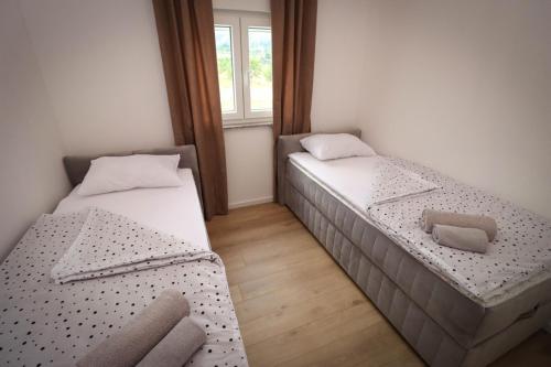 two beds in a small room with a window at Kuća za odmor Ana in Prozor