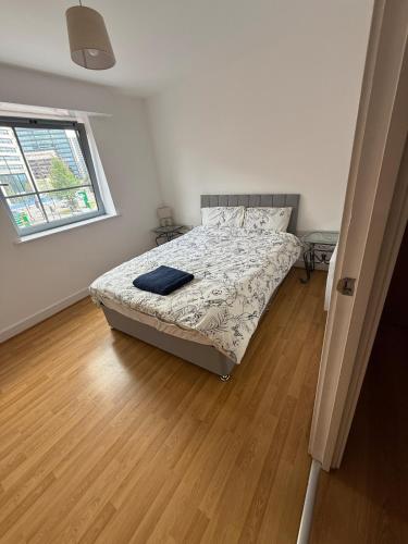 バーミンガムにあるStylish City Stay on Fleet Street, Modern Comfort in the Heart of Birminghamのベッドと木の床のある寝室