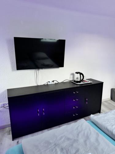 GüntherslebenにあるMirko's Gästezimmerの黒いドレッサー(壁に薄型テレビ付)