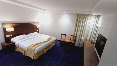 a hotel room with a bed and a television at Doolve Hotel Al Khobar in Al Khobar