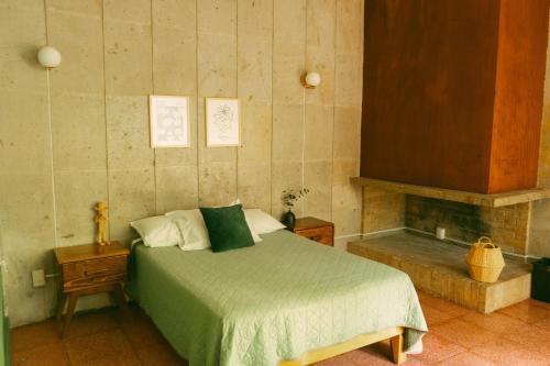 a bedroom with a bed with a green comforter at Casa Sabina in Guadalajara