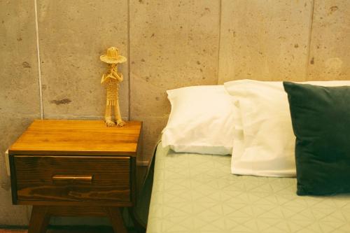 a bed with a table with a hat on it at Casa Sabina in Guadalajara