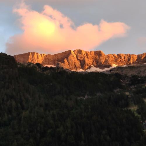 a view of a mountain with the sun setting at Cuore Alpino in Chiusaforte