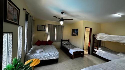 a room with two beds and a couch in it at Pousada Summer Beach by Itaúna in Saquarema