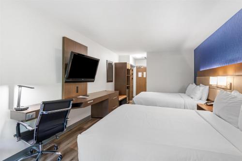 a hotel room with two beds and a desk and a tv at SureStay Plus Hotel by Best Western Mammoth Lakes in Mammoth Lakes