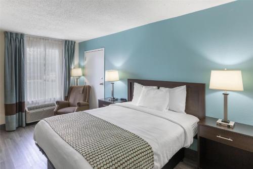 a hotel room with a large bed and a chair at SureStay Plus Hotel by Best Western Asheboro in Asheboro