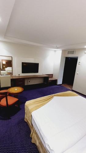 a hotel room with a bed and a flat screen tv at Doolve Hotel Al Khobar in Al Khobar