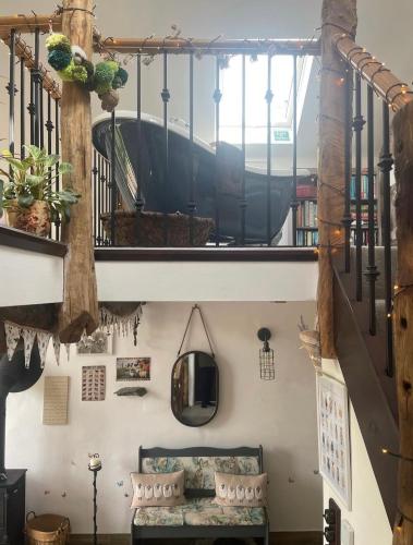 a room with a staircase with a couch and a mirror at Rosie's Barn in Penrith