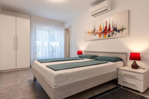 a bedroom with a large bed with a painting on the wall at Luksuzna kuća za odmor "Villa Romantica" in Kraljevica