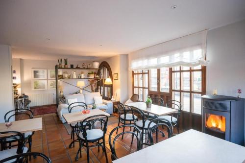 a living room with tables and chairs and a fireplace at Posada La Fuentona de Ruente in Ruente