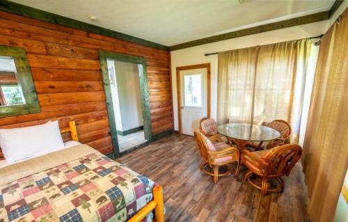 a bedroom with a bed and a table and chairs at Fishtale Lodge Cabins in Buchanan