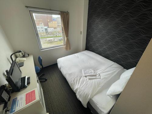 a small room with a bed and a window at Hotel All In Well in Hakodate